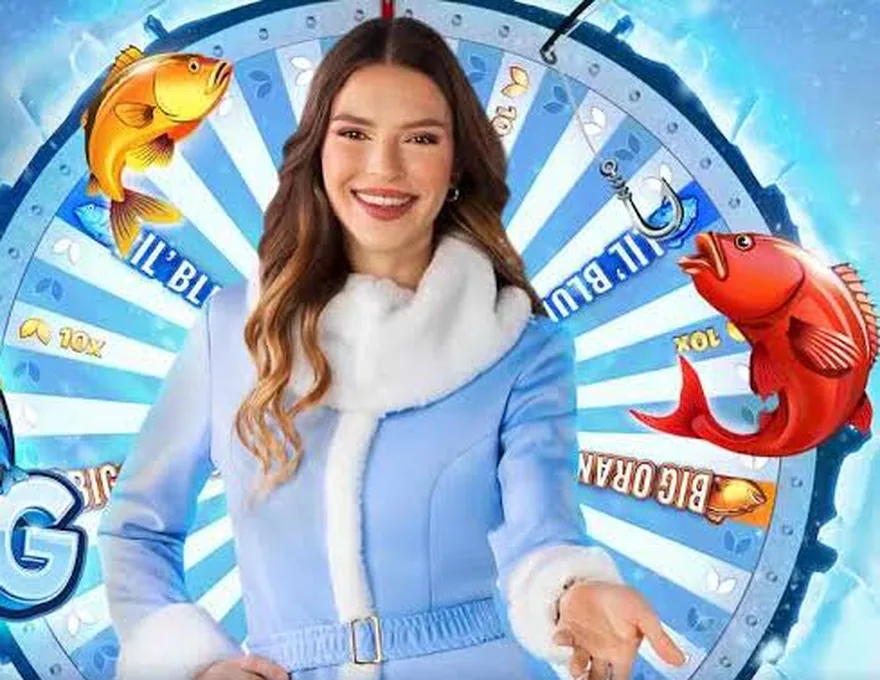 Presentadora de Ice Fishing Live junto a la rueda con casillas Lil' Blues y Big Oranges